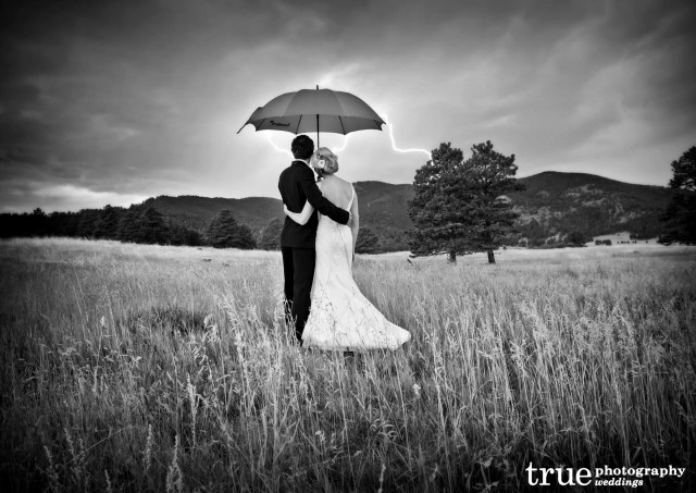 black-and-white-photo-of-wedding-during-lightening-storm-with-red-umbrella